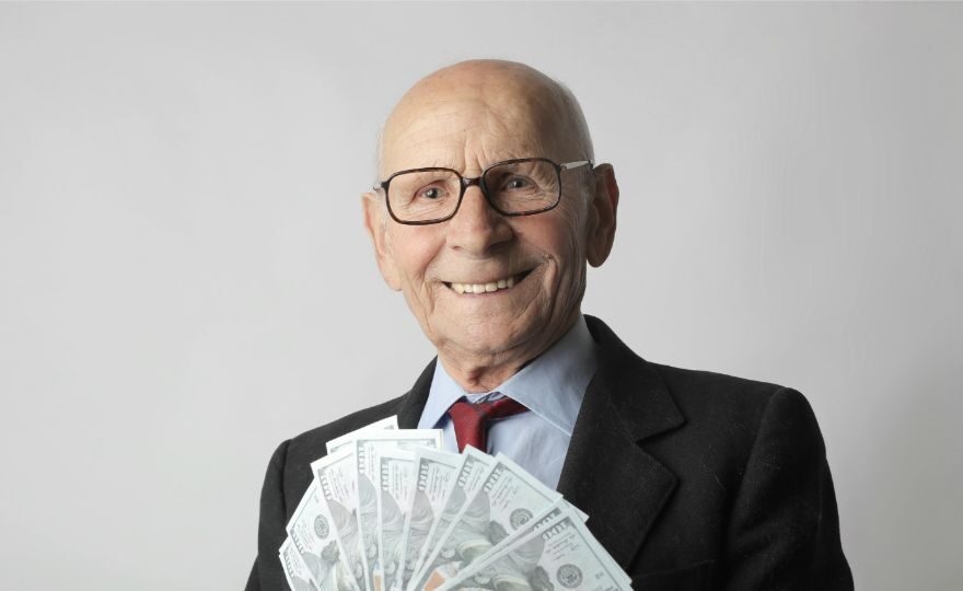 Man in black suit holding dollar bills