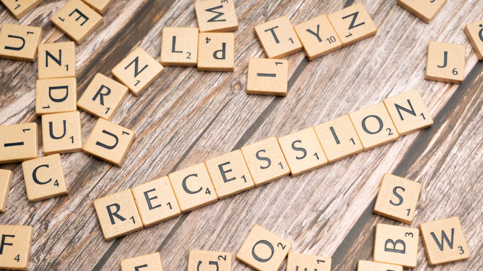 Wooden letter tiles spelling out the word 'Recession' symbolizing economic downturn