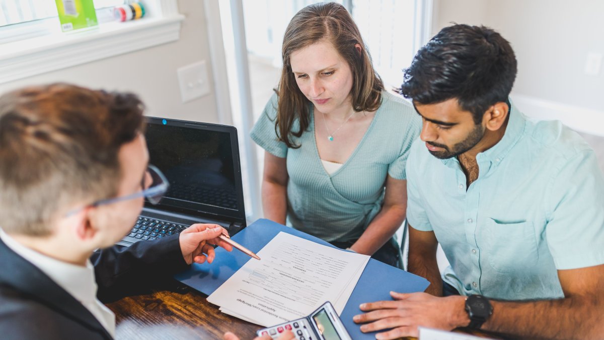 Professional financial advisor engaging in discussion with a couple in an office setting